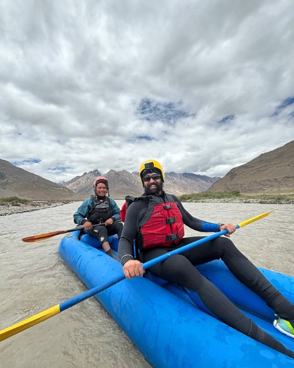 Guides rafting a Himalayan river under dramatic skies