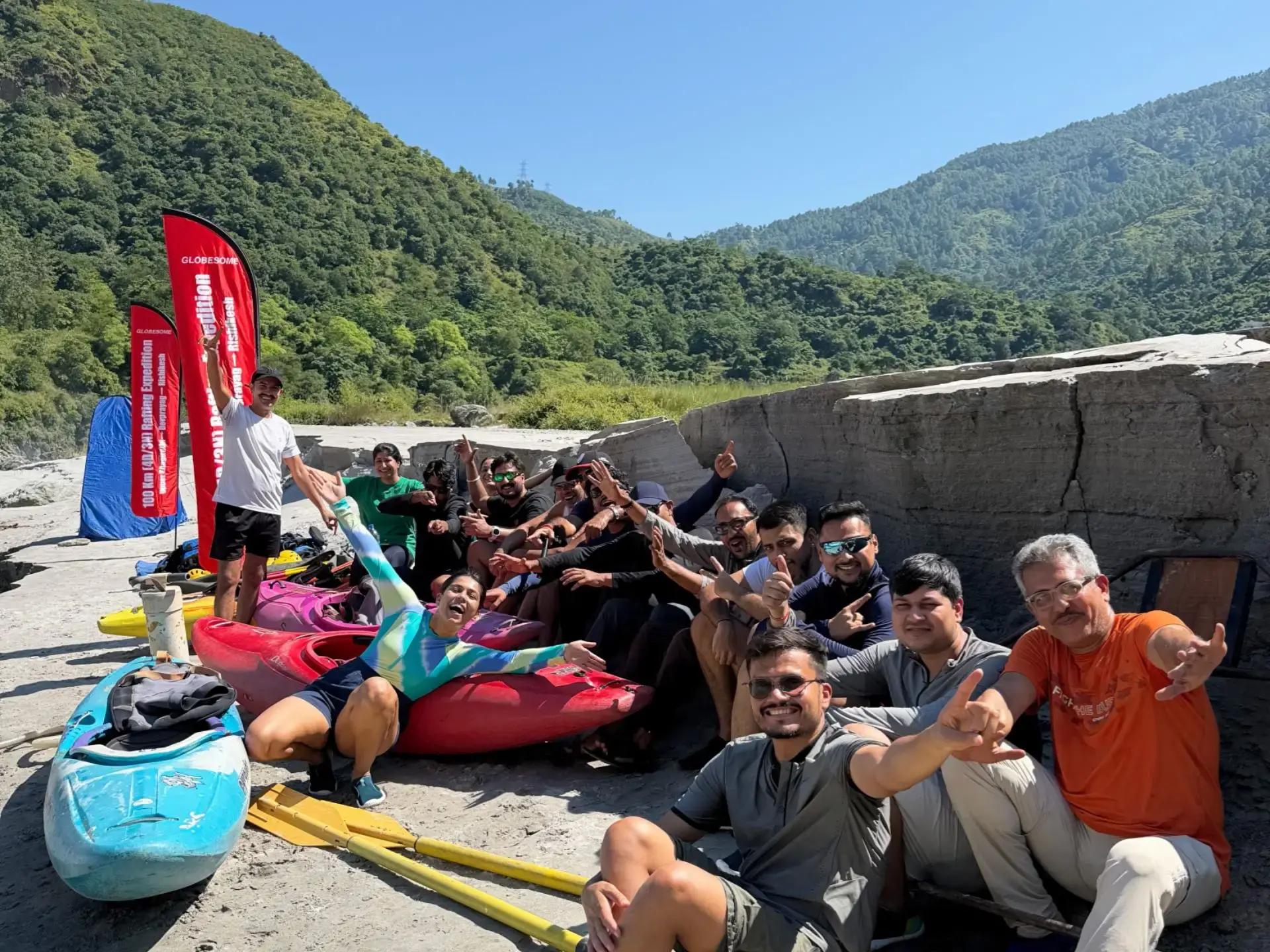 A guided rafting group relaxing together beside kayaks
