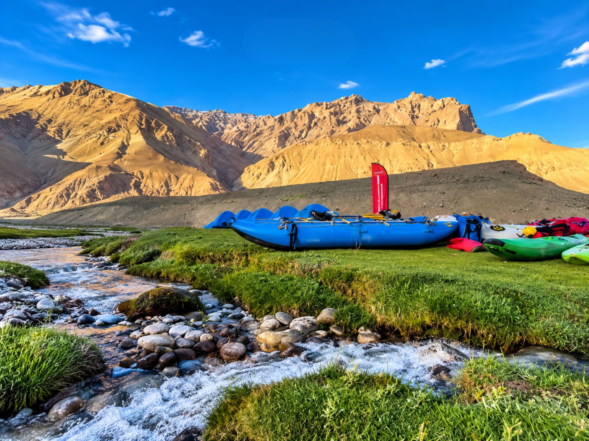 Blue expedition raft at a mountain campsite beside a stream