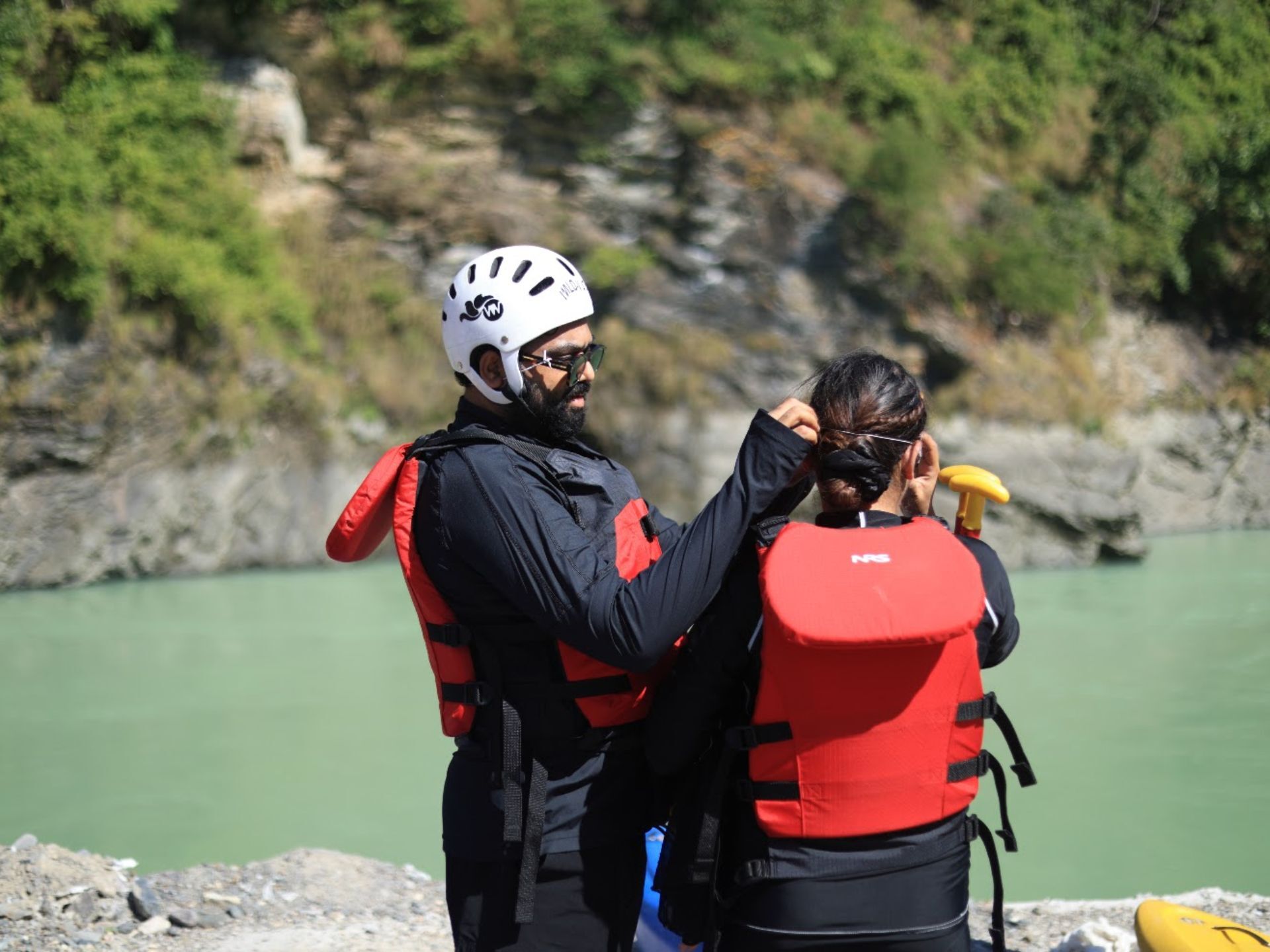 Guide fitting a helmet for a guest before the 36 KM Ganga rafting trip