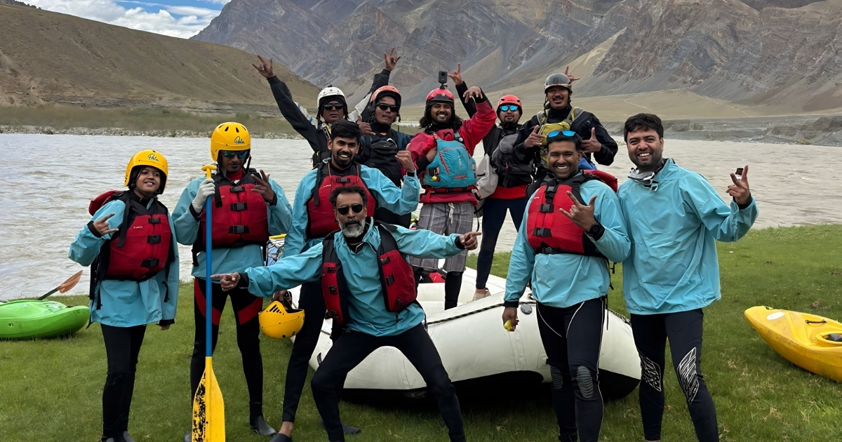 Rafting group in Ladakh posing with their raft beside the Zanskar river