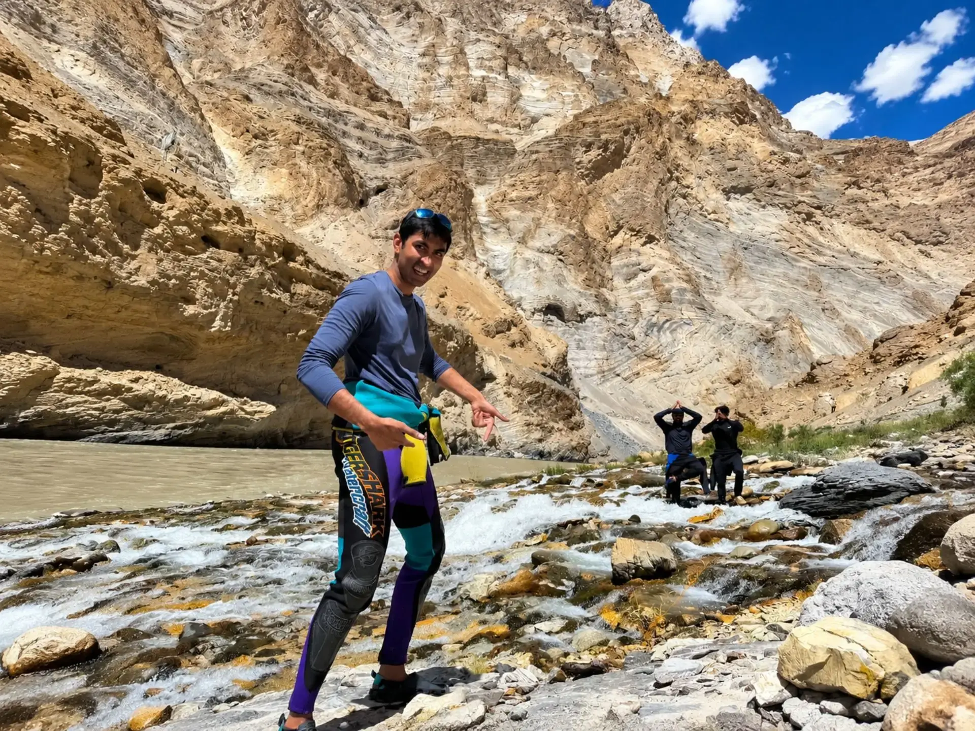 Family rafting group posing safely beside a Himalayan waterfall