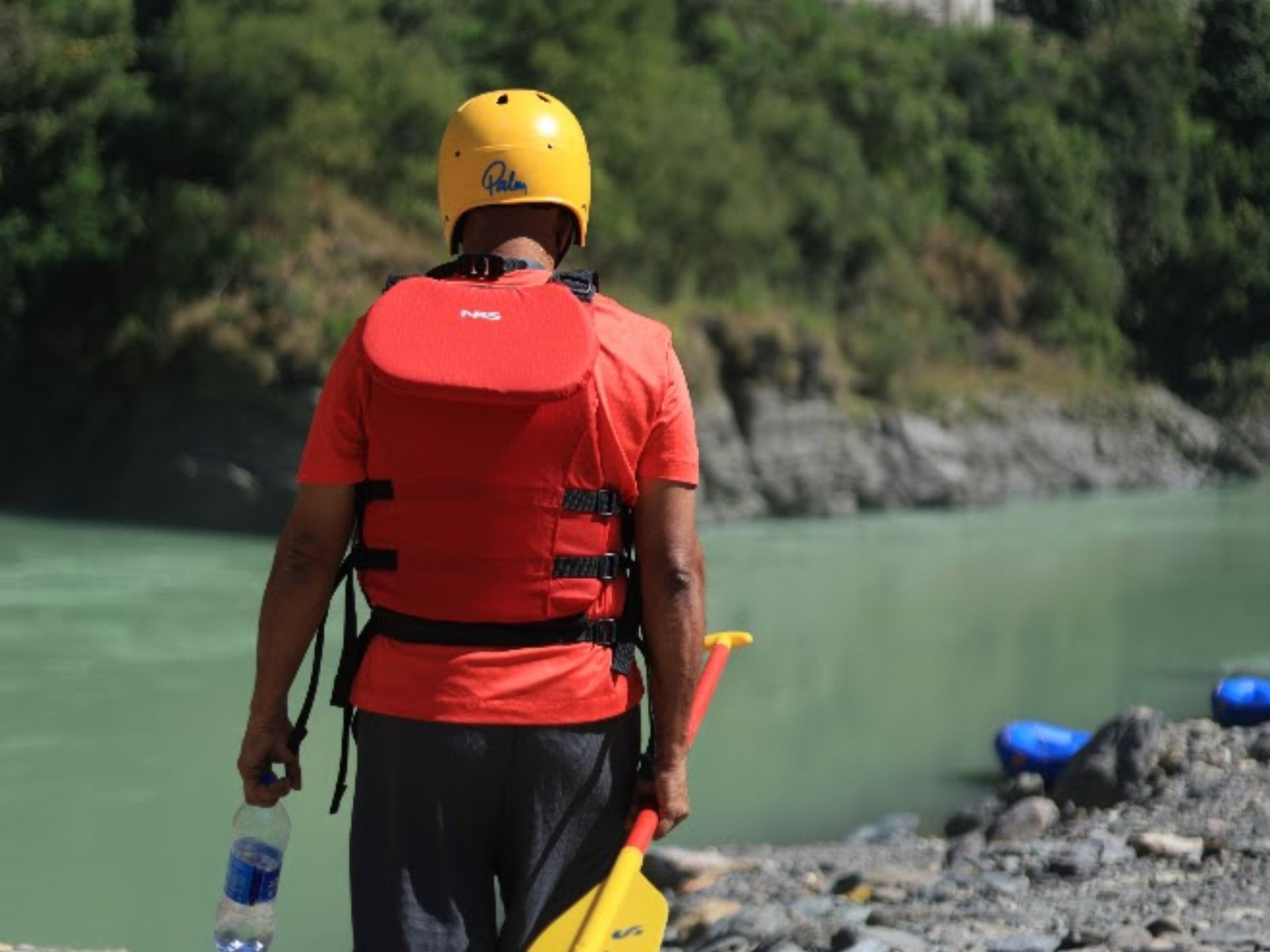 Rafter with paddle on the Ganga riverside at the weekend departure point