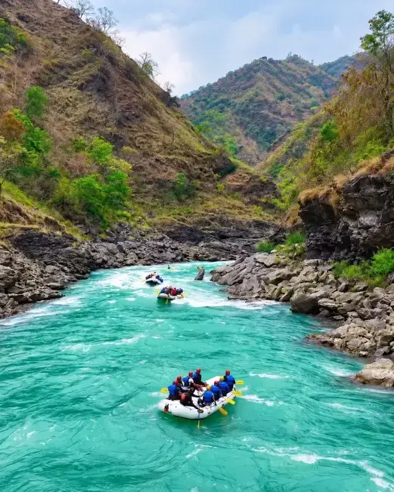 Rafts running turquoise Ganga rapids through the Rishikesh canyon
