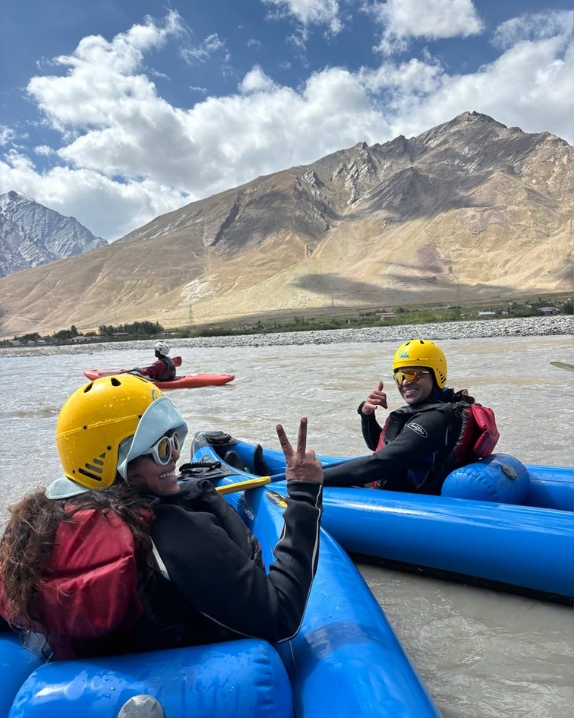 Rafters in yellow helmets enjoying a Himalayan river trip with mountain views
